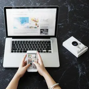 Closeup hands using mobile phone computer laptop black marble tableDisplay AdsRich Media